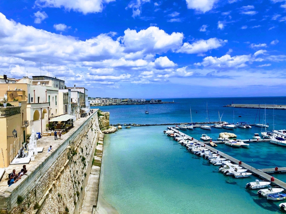 Kustgezicht van een historische stad met een haven en jachthaven.