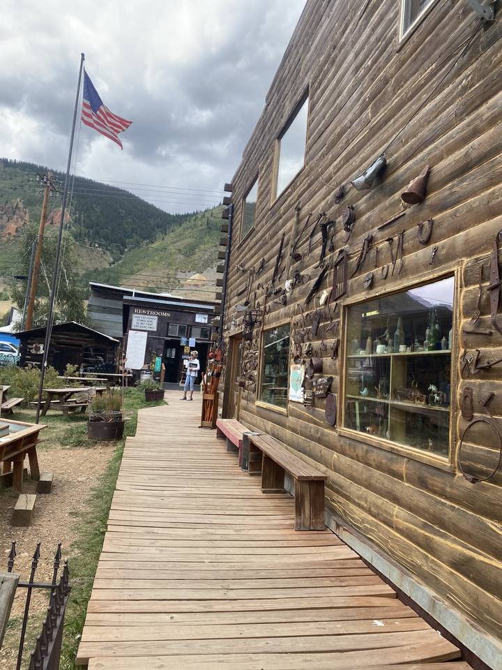 Bâtiments rustiques avec passerelles en bois et drapeau américain.