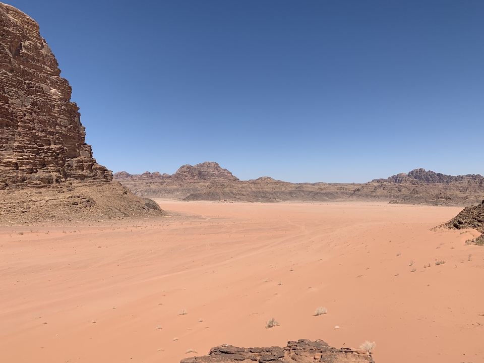 Desert landscape with rocky formations under a clear blue sky.