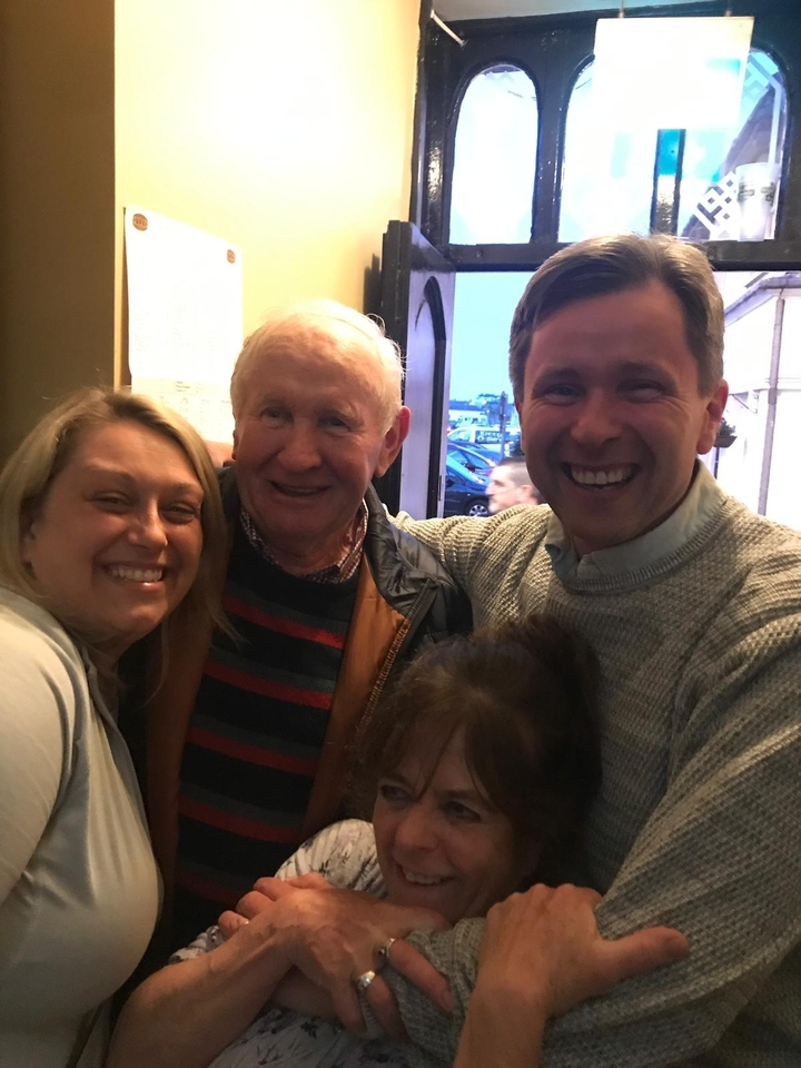 Groupe de personnes souriantes qui posent à l'intérieur d'un pub.