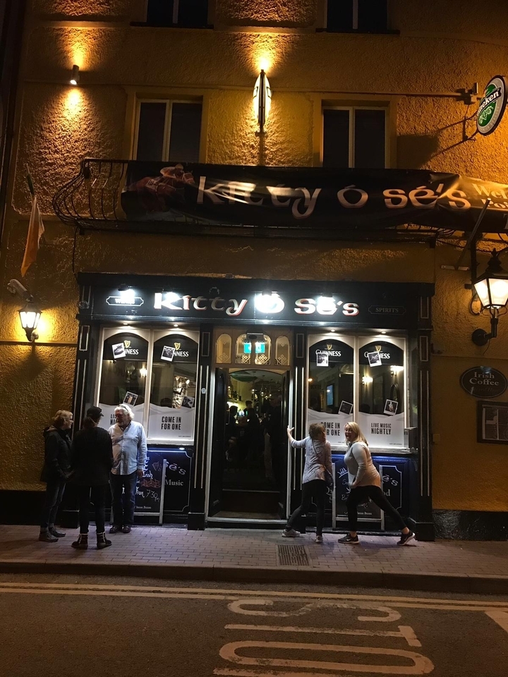 Extérieur du Pub de Kitty avec des gens qui entrent.