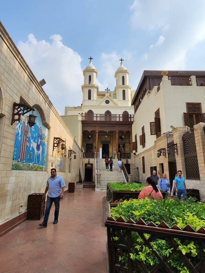 People walking around a historic church courtyard.