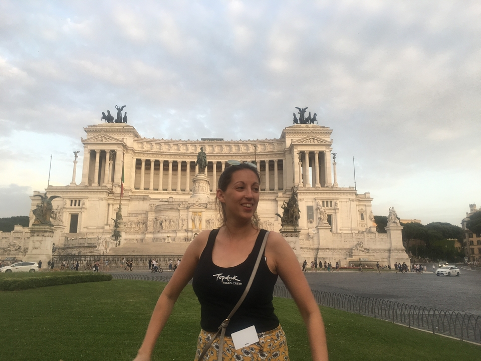 Woman posing in front of a grand architectural monument.