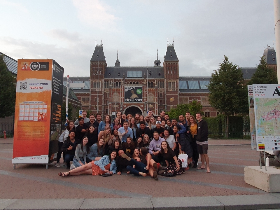 Large group of people posing in front of an iconic museum.