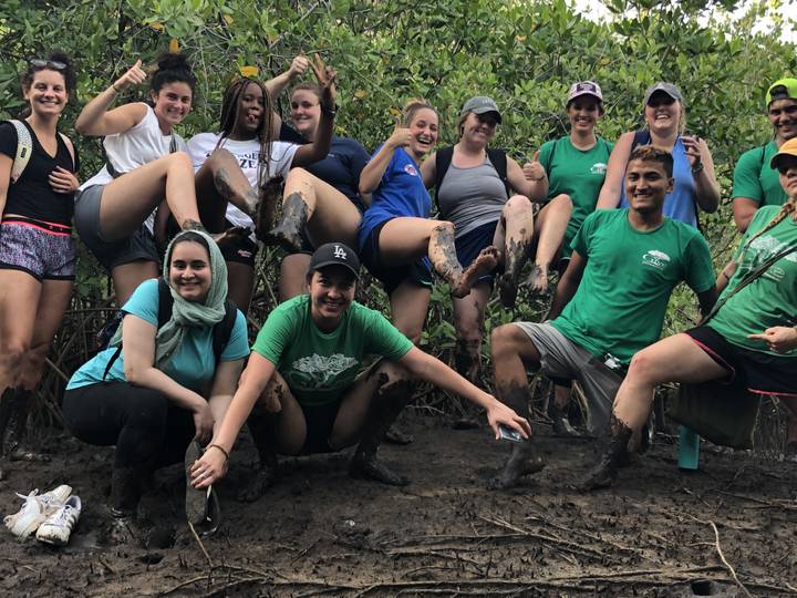 Group showing off muddy fun in a natural setting.