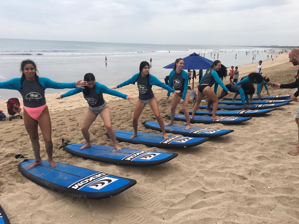 Surf lesson on the beach with a group of learners.