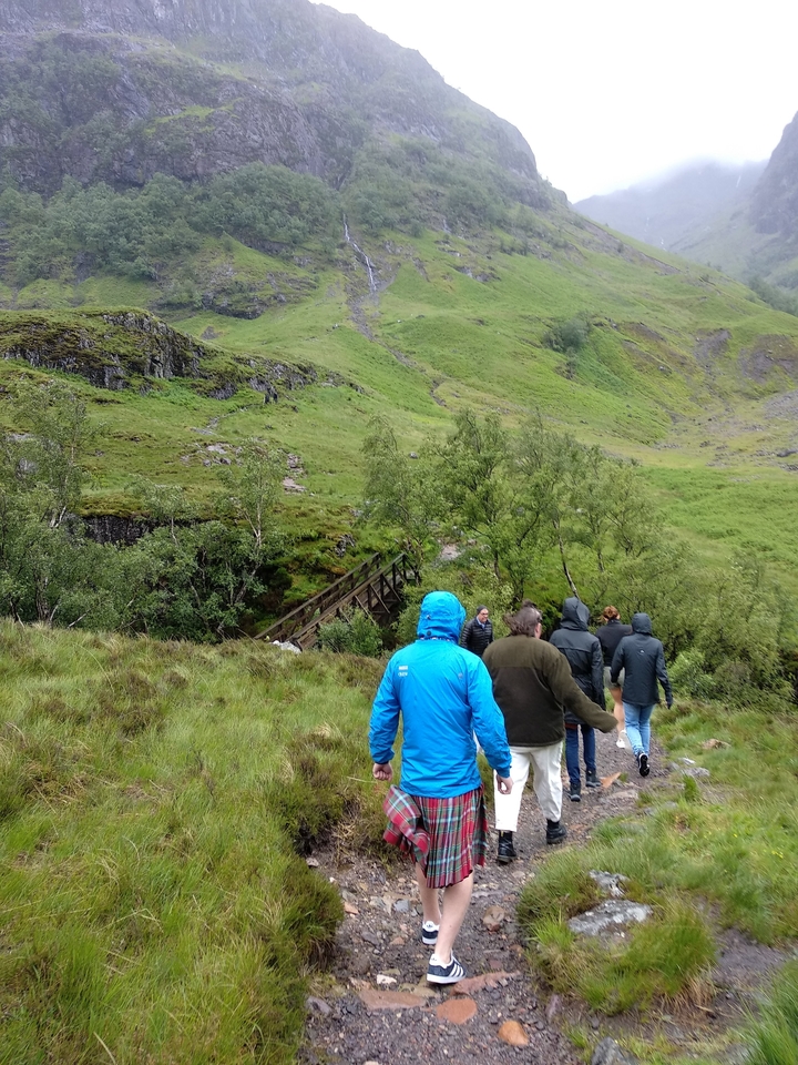 Group of people hiking on a trail in the countryside.