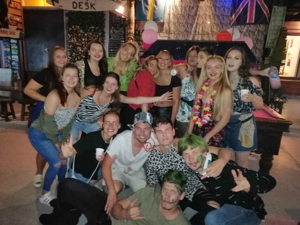 Group of people in a party setting, dressed colorfully.