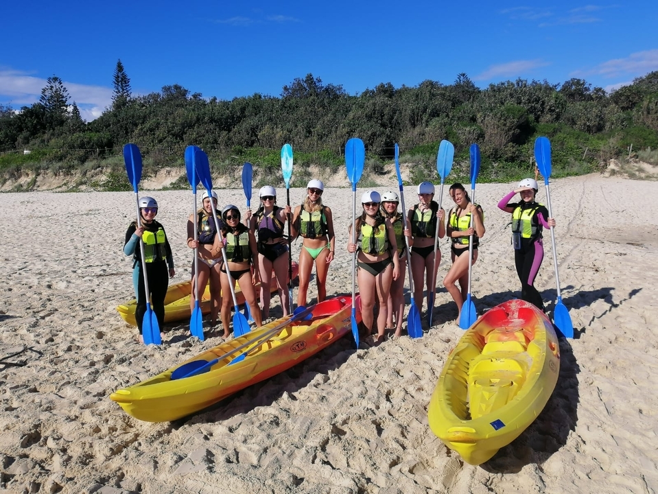 People on a beach with kayaks.