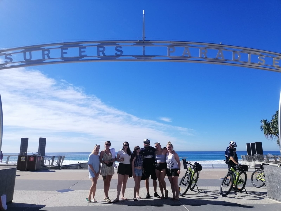 Group of people under Surfers Paradise archway.