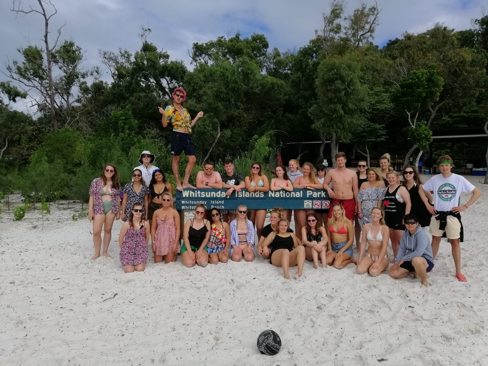 Group of people posing with Whitsunday Islands National Park sign.