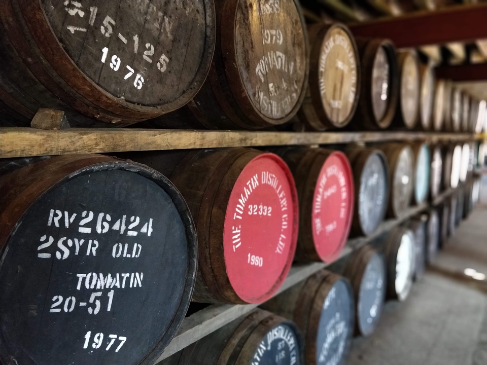 Barrels lined up in a distillery warehouse.