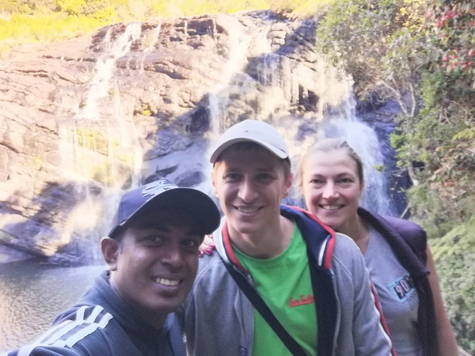 Trois personnes posant devant une cascade, flou.
