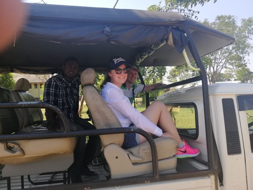 Des personnes assises dans un véhicule de safari ouvert, prêtes pour une excursion.