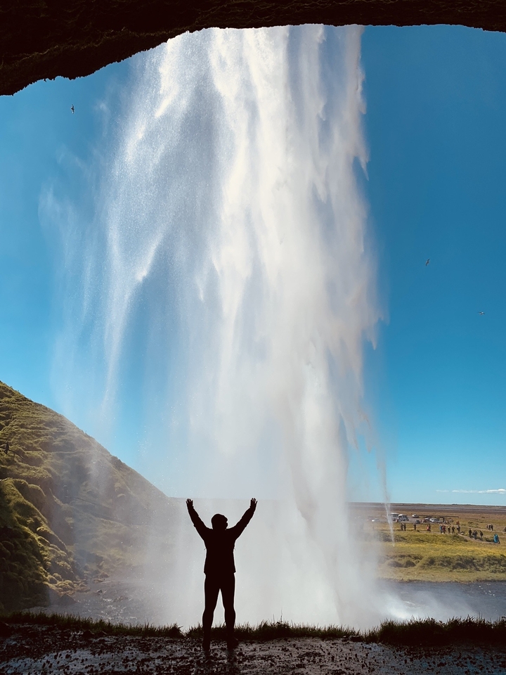 Powerful geyser eruption against a clear blue sky.