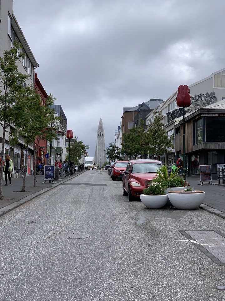 Street view with colorful buildings and a cathedral.