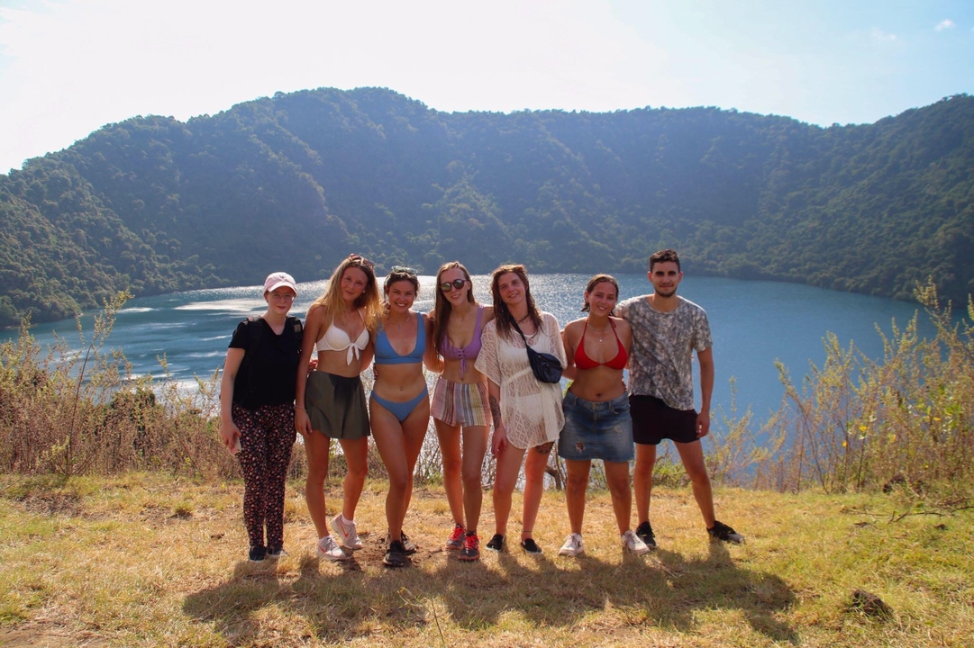 Groupe posant avec un lac pittoresque et un paysage de montagnes en arrière-plan