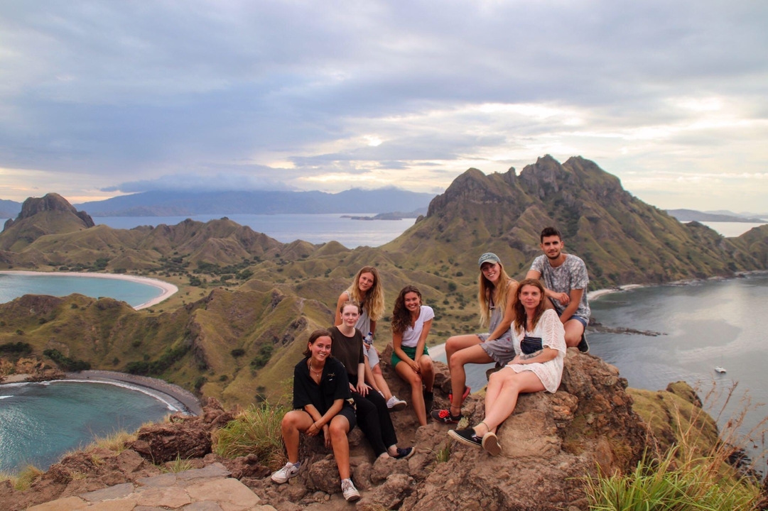 Groupe de personnes avec une vue imprenable sur la montagne et la mer
