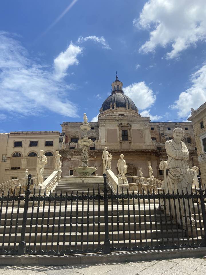 Historic building with sculptures under a blue sky.