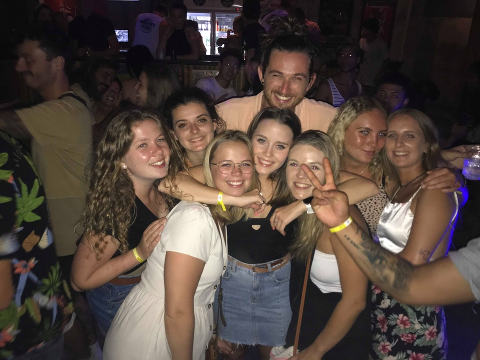 Group of people smiling at a party or night event.