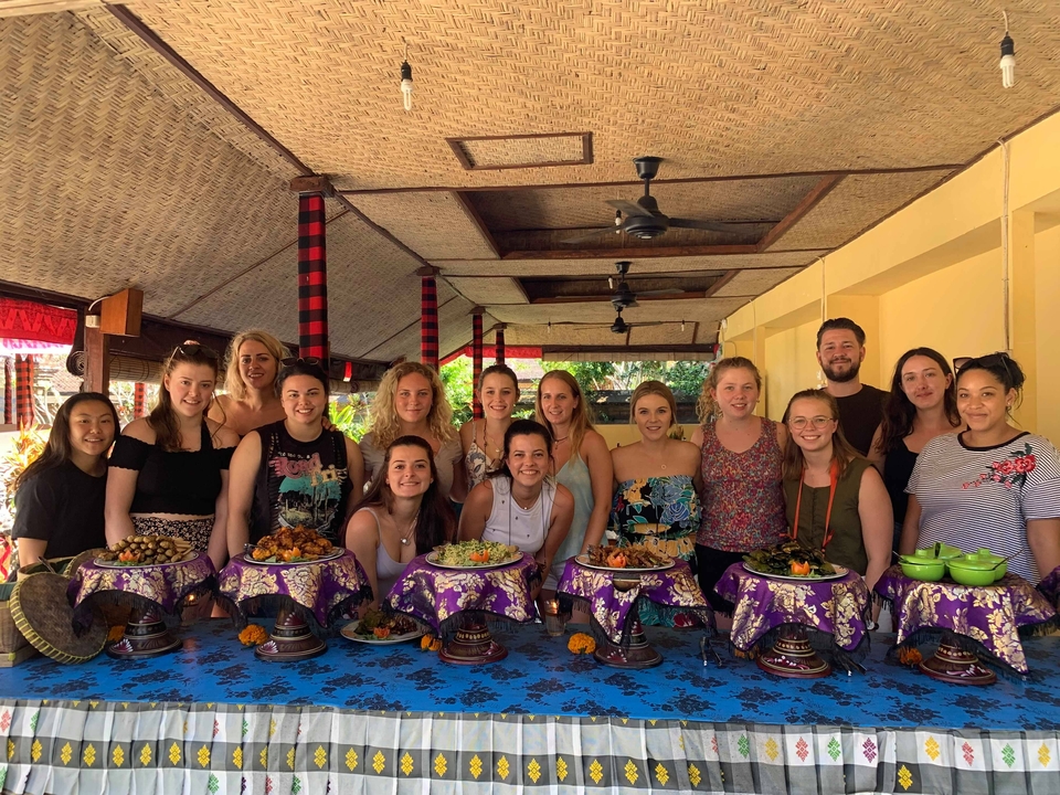 Group of people posing in front of a buffet setup.