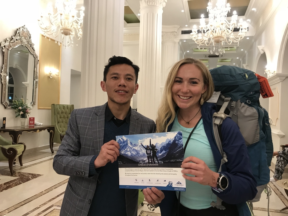 Deux personnes posant avec un certificat de randonnée à l'intérieur.