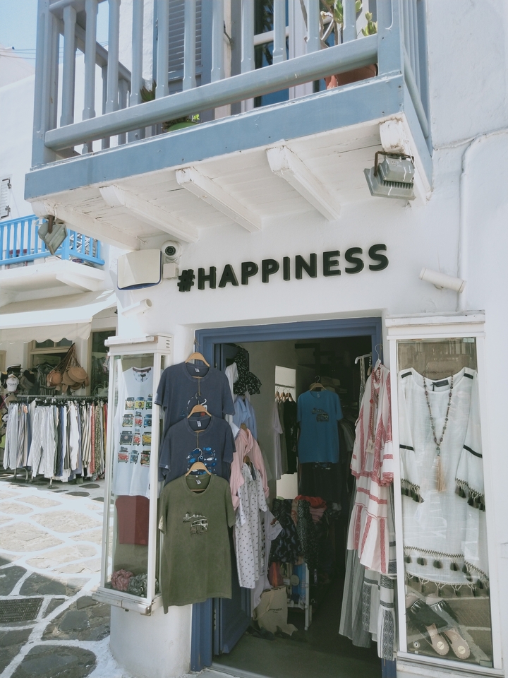 Shopfront with the sign '#HAPPINESS' on the wall.