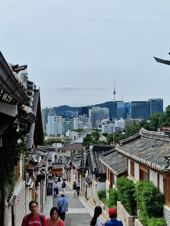 View of a city through traditional Korean rooftops.