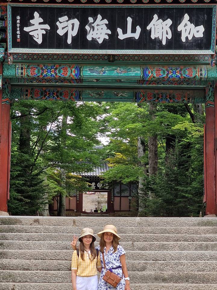 People posing on stone steps with a traditional gate.
