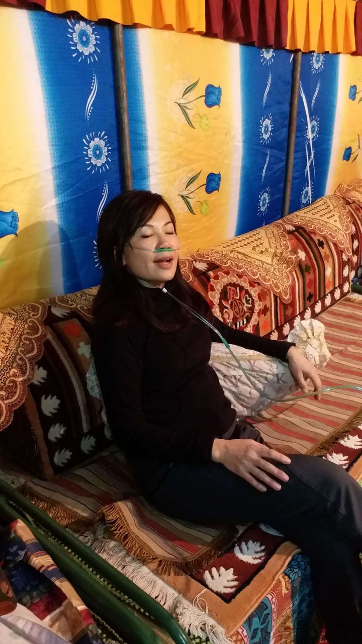 Personne assise avec un tube à oxygène.