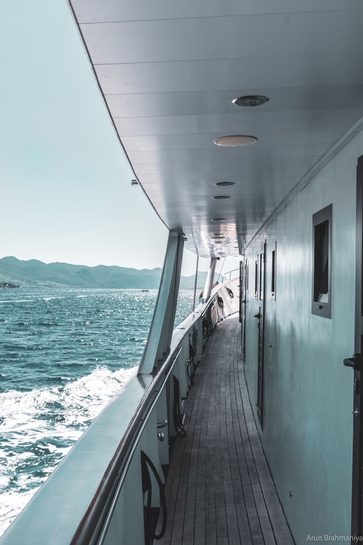 Side view of a boat with a sea and mountain view