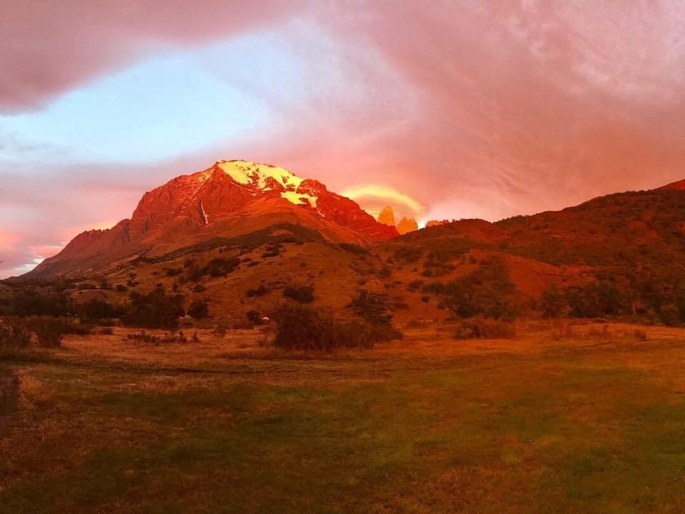 Mountain bathed in warm light with dramatic clouds.