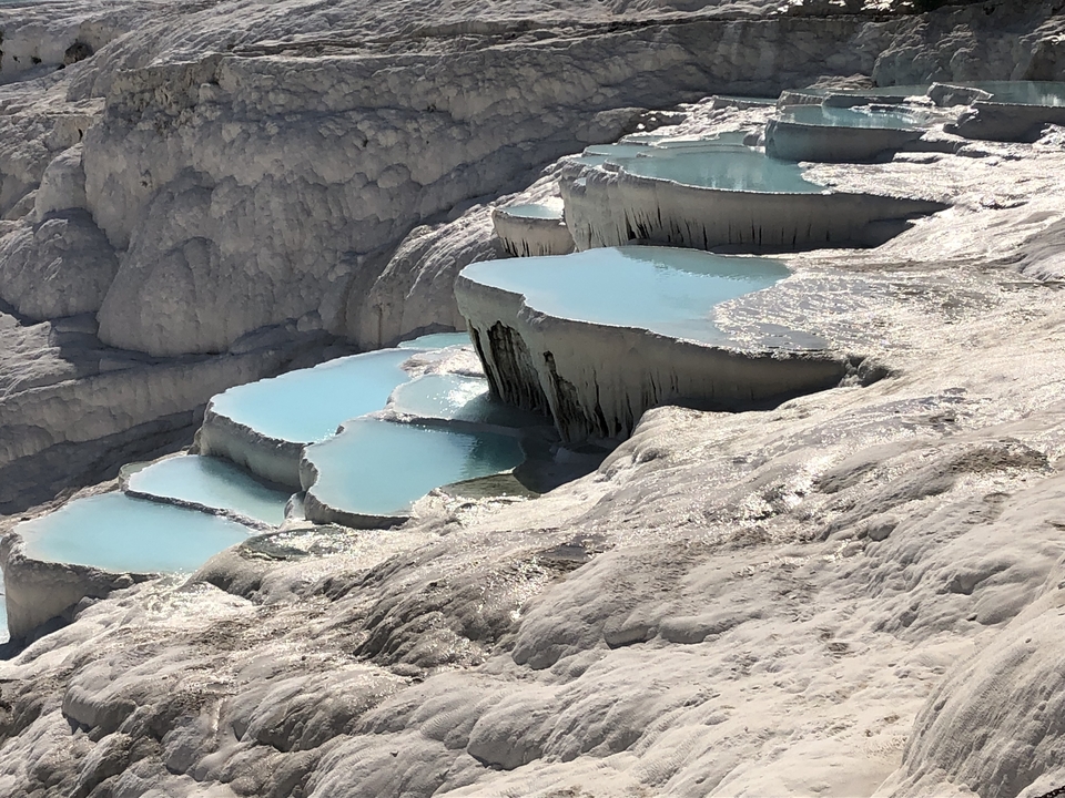 Natural thermal pools at Pamukkale with vibrant blue water.