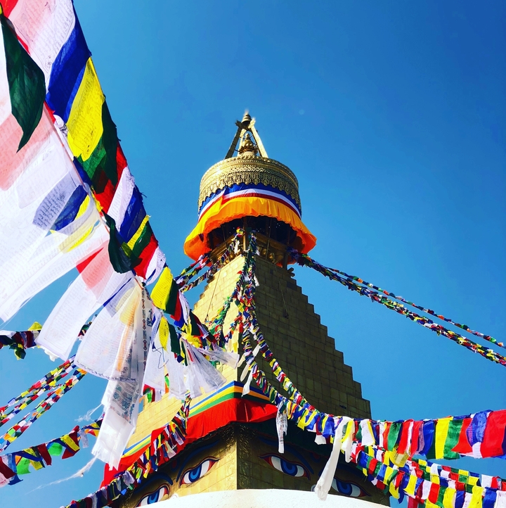 Drapeaux de prière colorés et stupa sur fond de ciel bleu.