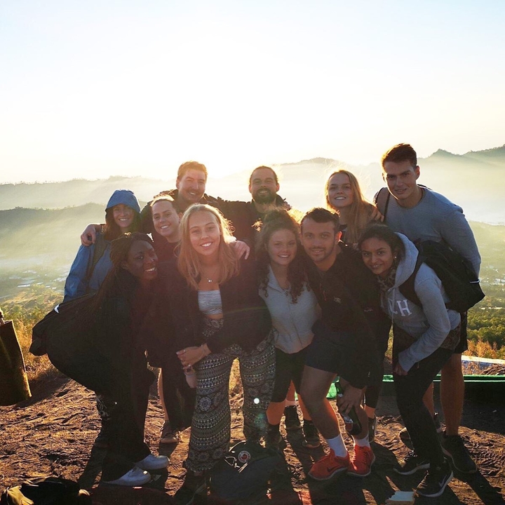 A group of hikers posing with a scenic backdrop.