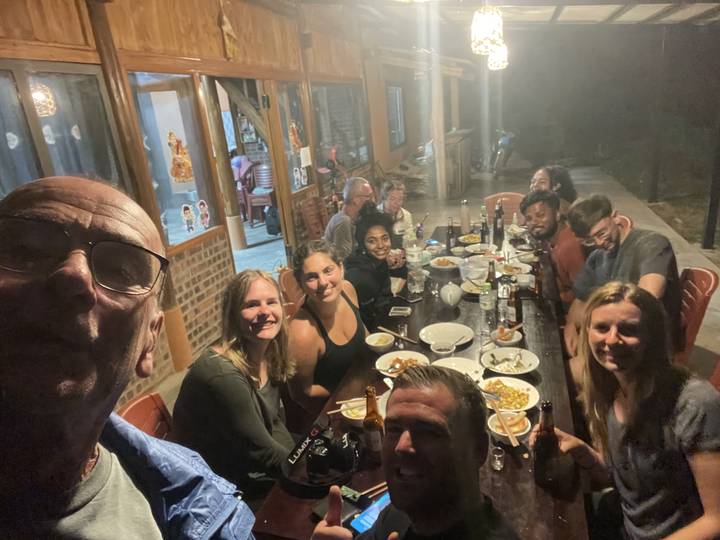 Group of people dining indoors at a large table.