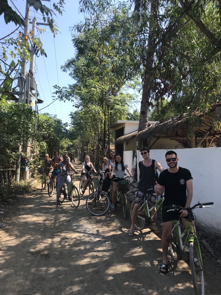 Group of cyclists posing with bicycles on a street.