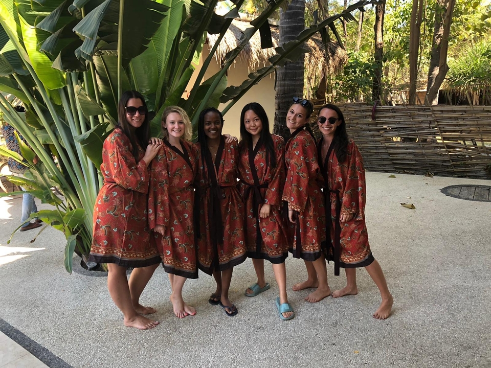 Women in traditional dress standing in a garden.