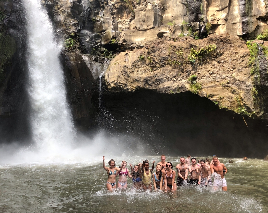 Group of people enjoying a waterfall.