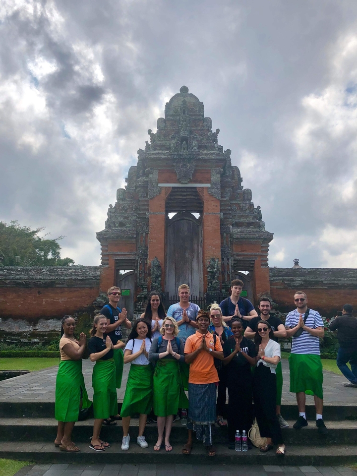 Group posing in front of a historical temple.