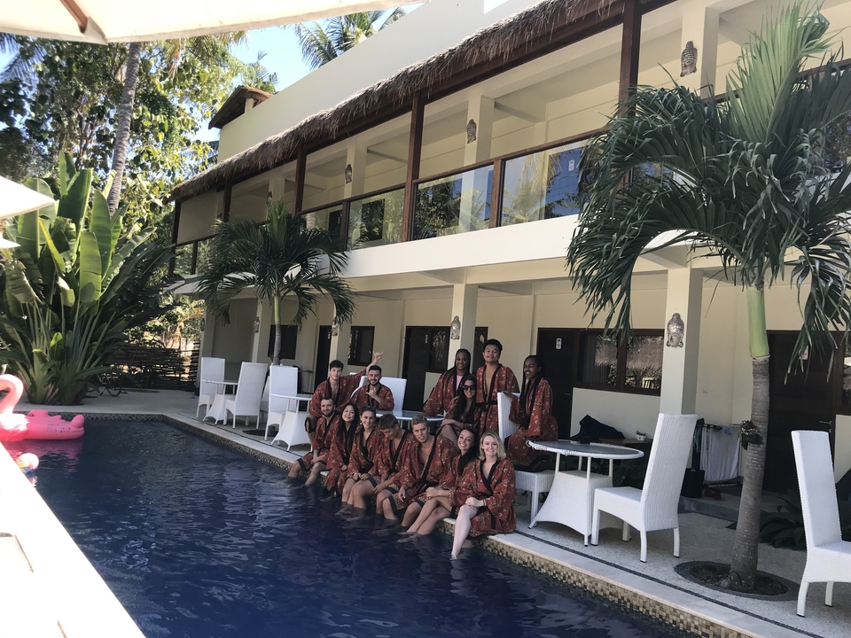 Group of people in traditional dress by a pool.