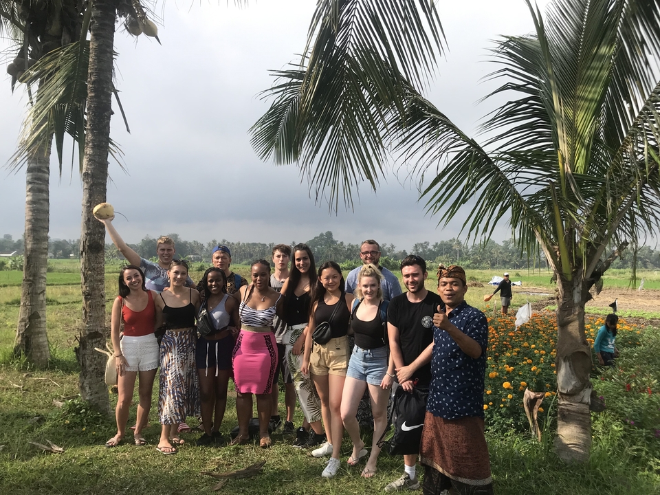 Group posing in a garden with palm trees.
