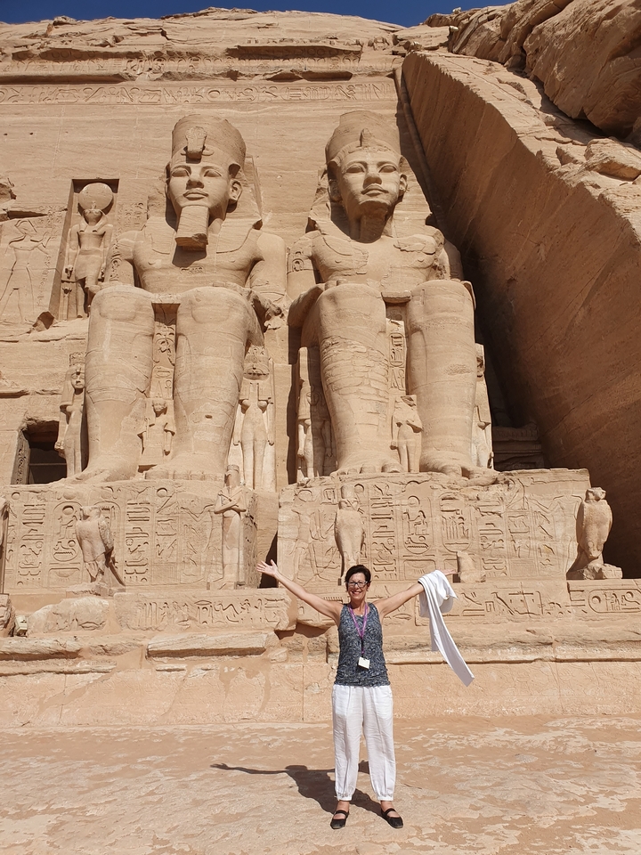 Person posing in front of magnificent ancient statues.
