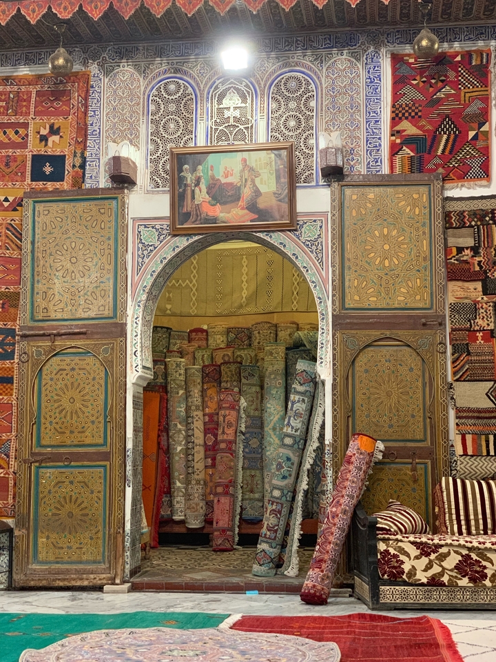 Innenraum eines Geschäfts mit bunten Textilien und Teppichen.