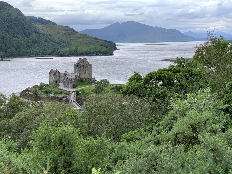 View of Eilean Donan Castle surrounded by water and greenery.