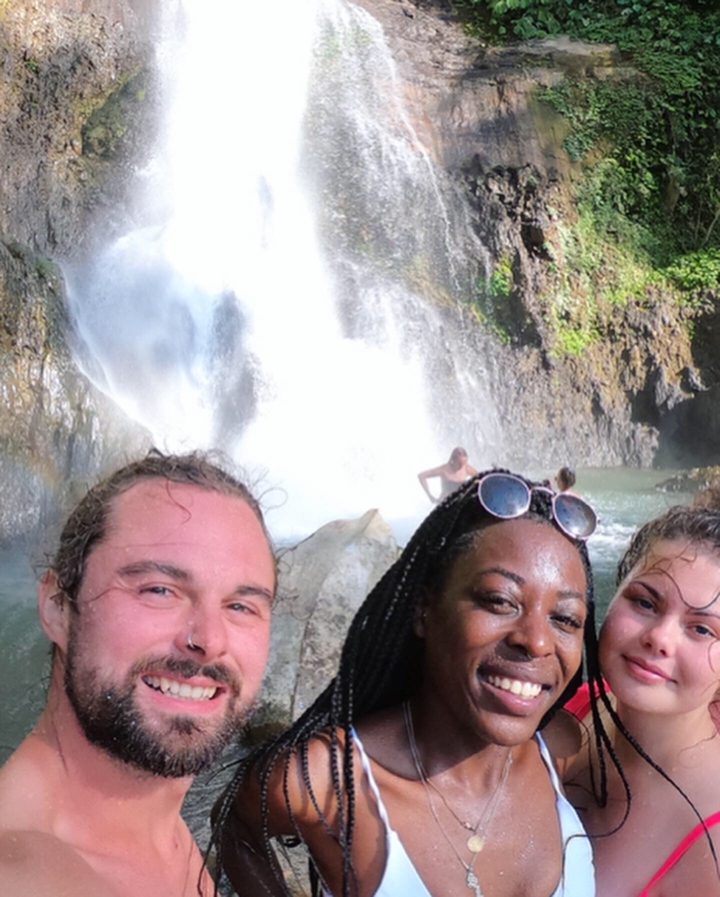 Three people in front of a waterfall, smiling.