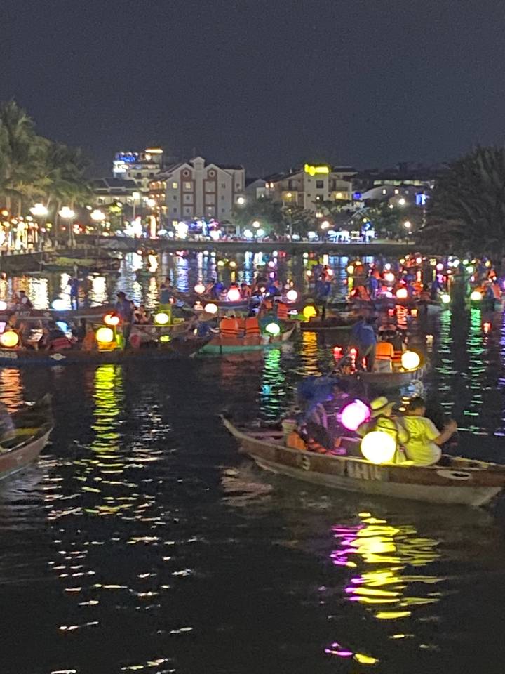 Bateaux décorés de lumières colorées la nuit.
