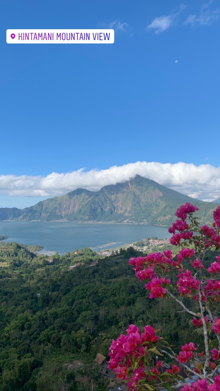Scenic view of a mountain with a cloud-covered peak and a lake.