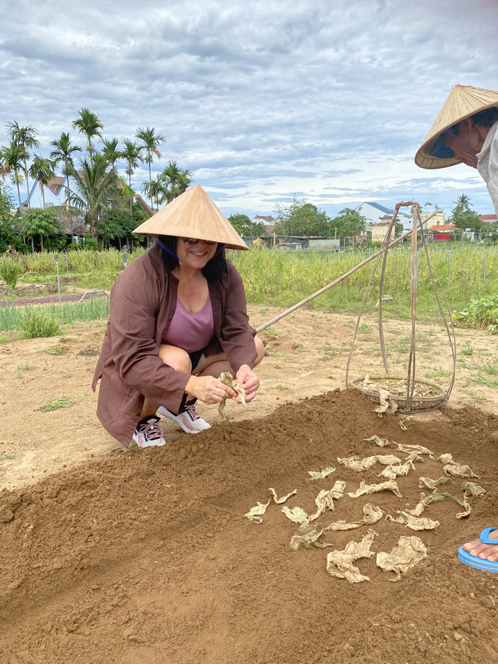 A person wearing traditional clothing, working in a field.