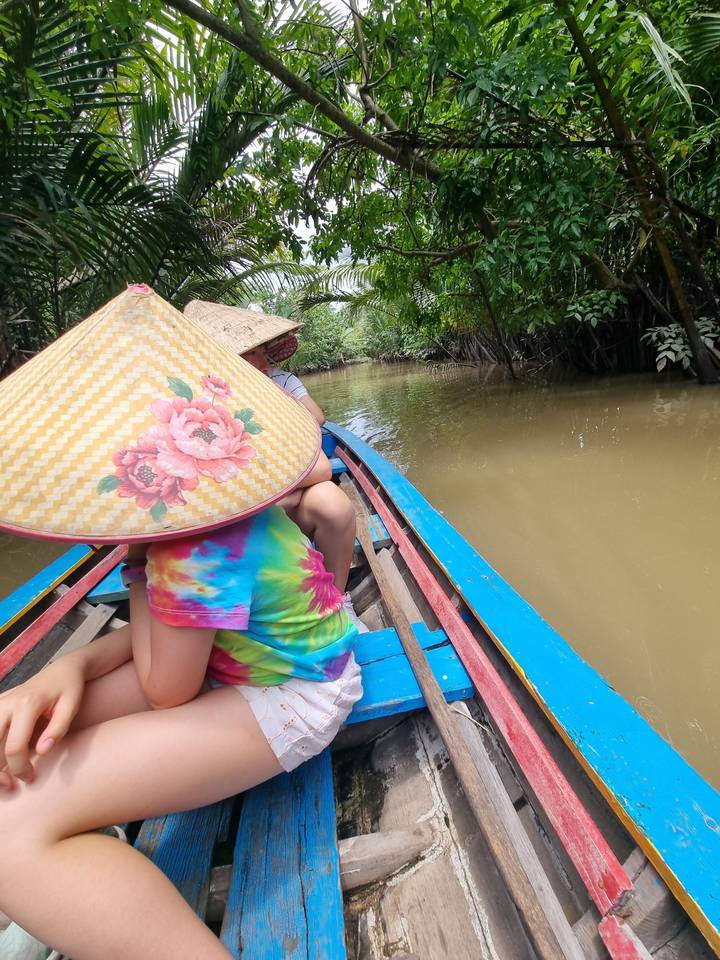 People in a boat on a jungle waterway.